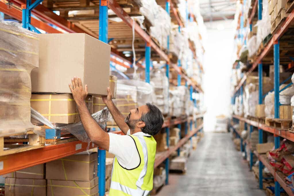 Trabalhador logístico movimentando mercadoria que passou por paletização